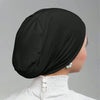 Un gorro interior de chándal negro para hijab, usado por una mujer con pendientes de perla.