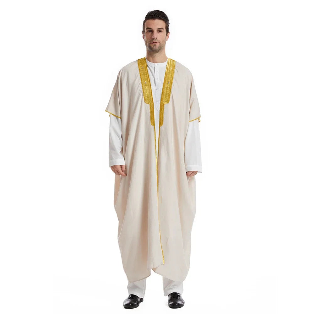 Mann trägt beige Jubba-Thobe Kaftan mit goldenen Zierleisten über einem weißen Hemd.