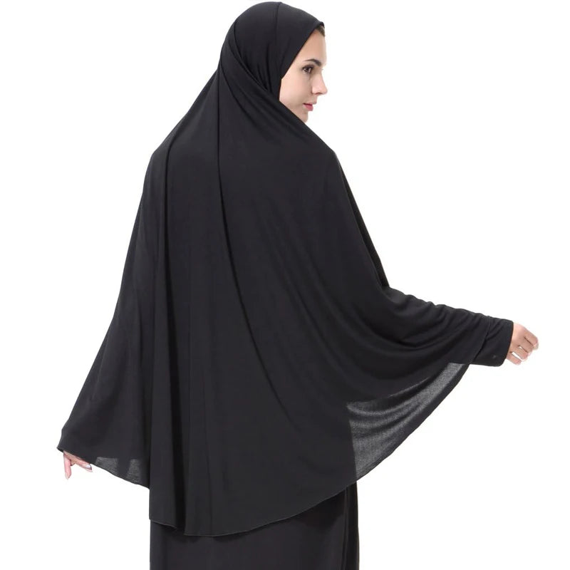 Una mujer vistiendo un elegante pañuelo hijab negro ligero para la modestia.