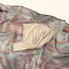 Beige Aquarell-Chiffon-Instant-Hijab drapiert auf einem durchscheinenden, marmorierten Stoffhintergrund.