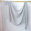 Foulard hijab de couleur gris clair drapé sur un cintre en bois.
