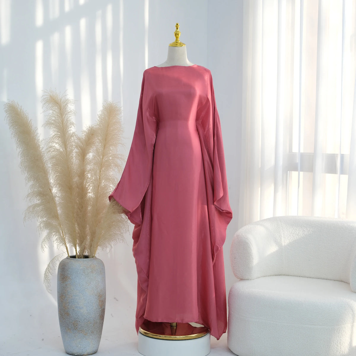 Langes, fließendes rosa Kaftankleid mit Schmetterlingsärmeln auf einem Mannequin.