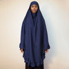 Eine Frau trägt einen marineblauen Diamant-Hijabschal mit gerafften Rändern.