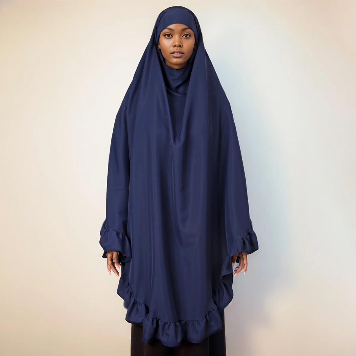 Eine Frau trägt einen marineblauen Diamant-Hijabschal mit gerafften Rändern.