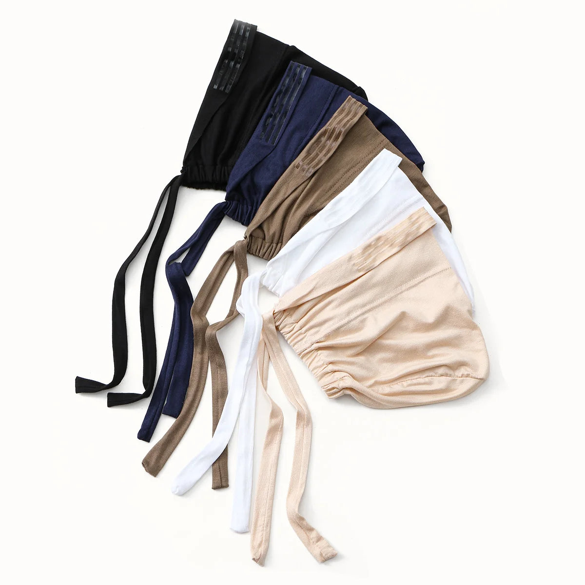 A collection of adjustable elastic headband hijabs in various earth tones including black, navy blue, beige, and white.