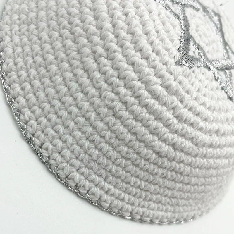 Gros plan d'une kippah ou yarmulke en tricot gris juive avec un motif décoratif.