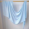 Écharpe de hijab couleur bleu clair uni drapée sur un cintre en bois.