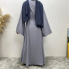 Lange, fließende graue Maxi-Abaya mit dunkelblauer Draperie, getragen drinnen.