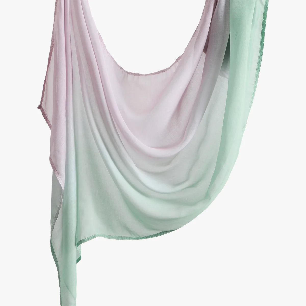 Un foulard hijab transparent et fluide dans des tons rose pâle et vert menthe, drapé élégamment.