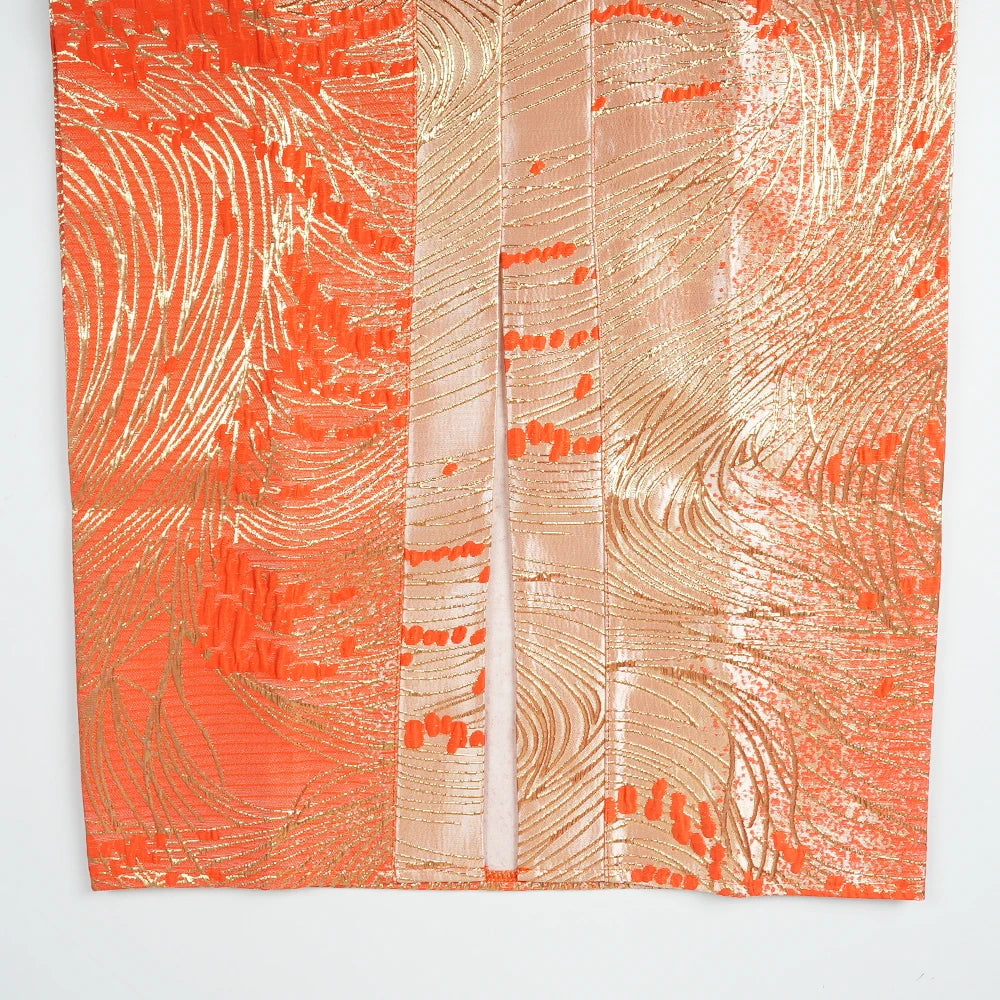Orange satin kaftan fabric featuring intricate gold embroidery and textured patterns