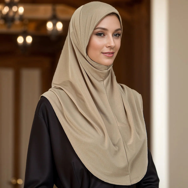 A woman wearing a beige elegant modal jersey hijab scarf and a black top.