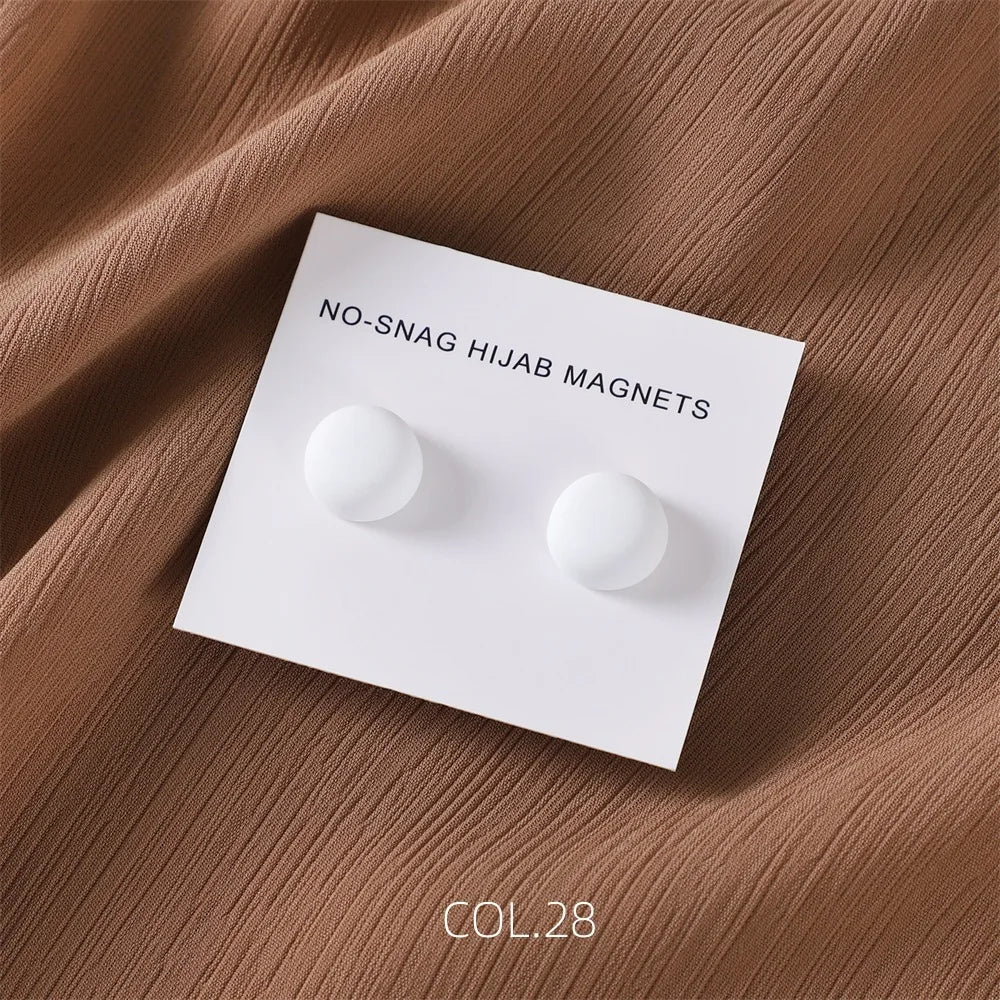 White no-snag hijab magnets on a white card against a brown fabric background