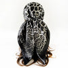 Pañuelo cuadrado de seda con estampado de leopardo negro atado alrededor del cuello de una persona