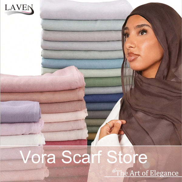 A woman wearing a brown rayon modal hijab scarf, displayed next to stacks of various colored scarves.