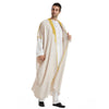 Ein Mann trägt einen beige-gelb-gestreiften Kaftan und ein weißes Hemd.
