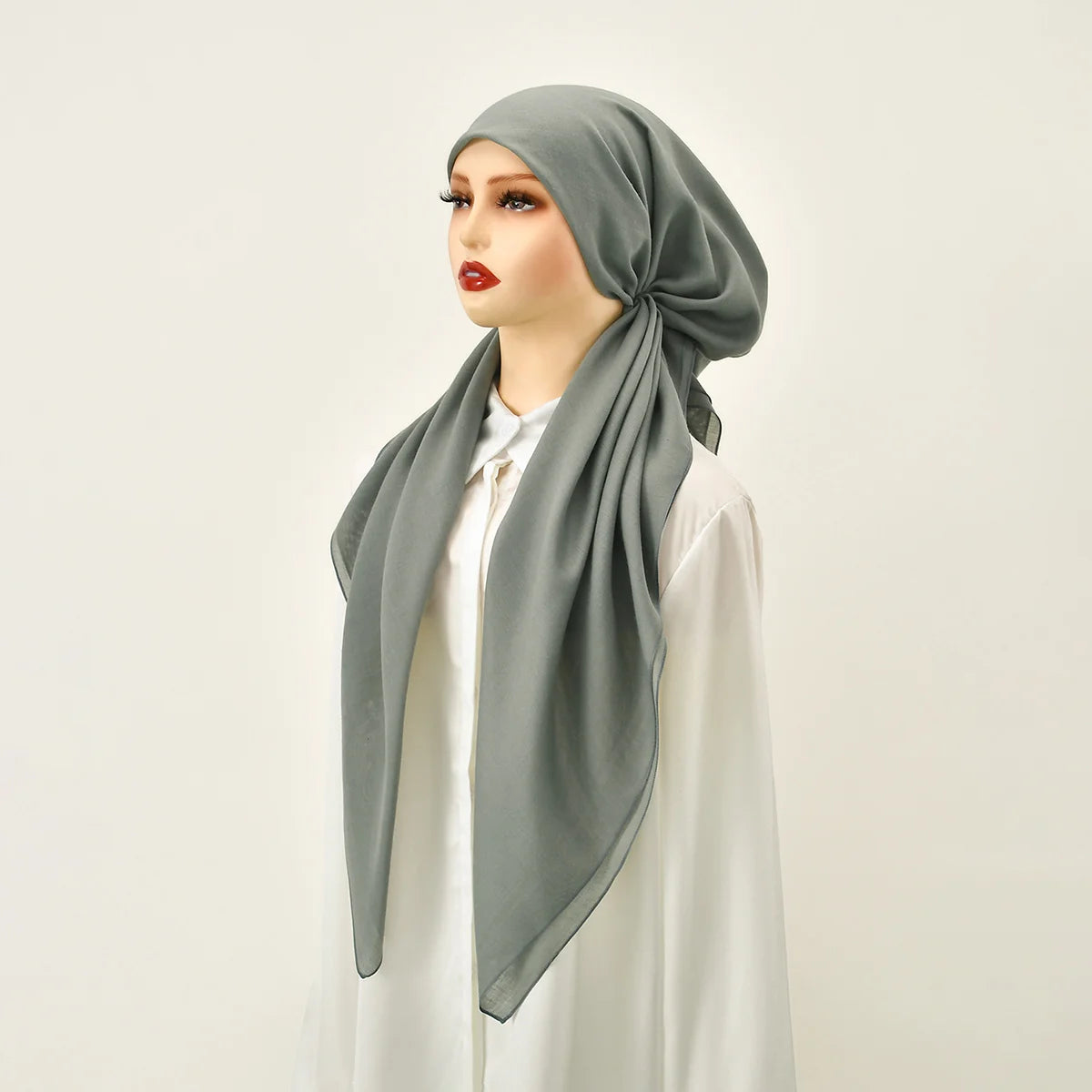 Una mujer usando una diadema elástica de diamantes grises premium para hijab, mirando hacia un lado.