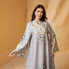 Una mujer modela una abaya larga gris claro con estampado de leopardo y adornos de diamantes azules.
