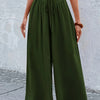Un mannequin portant un pantalon large vert olive à taille élastique avec des détails en dentelle