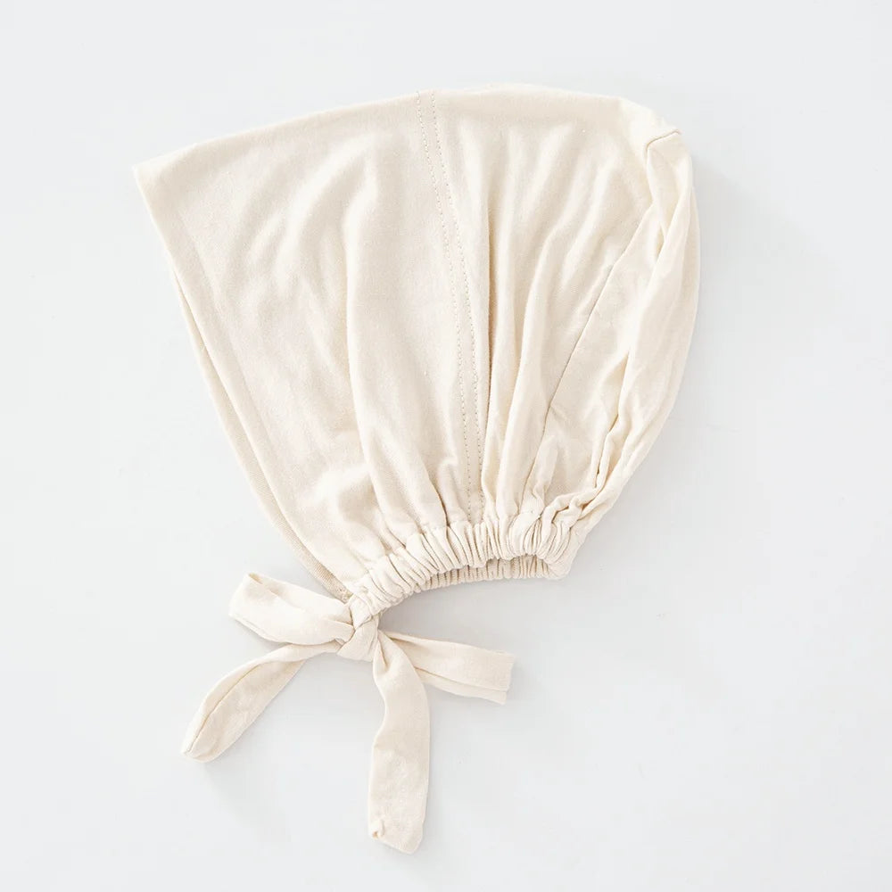 Beige mehrfarbiges Turban-Innenschal, gefaltet und unten zusammengebunden.