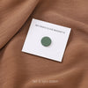 Set of three green no-snag hijab magnets displayed on brown fabric.