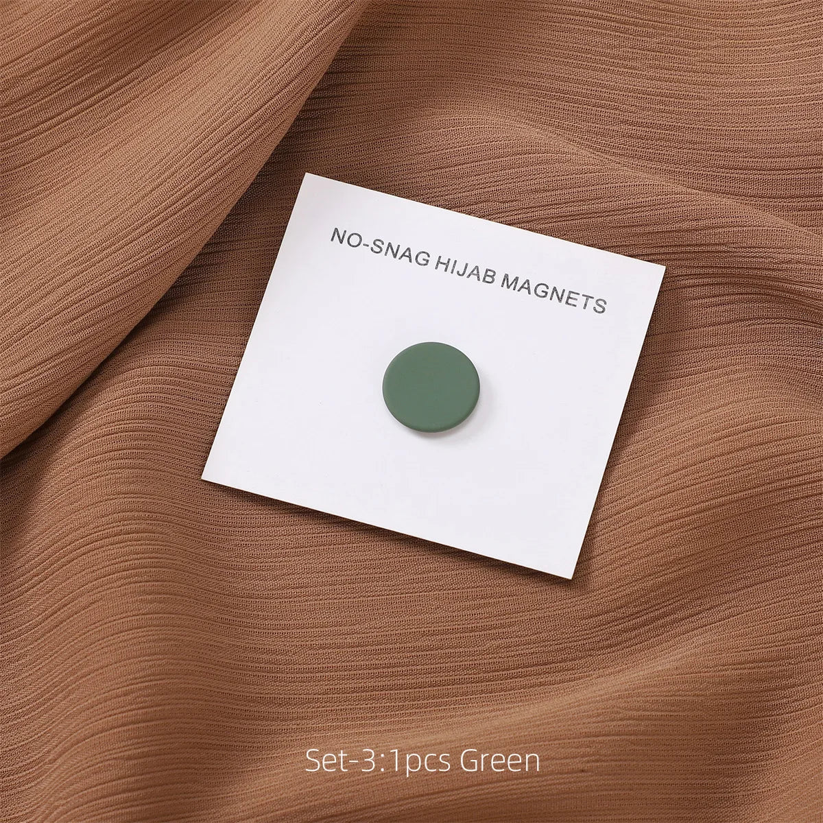 Set of three green no-snag hijab magnets displayed on brown fabric.