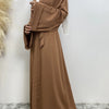 Eine Frau trägt ein fließendes, offenes Abaya Kaftan in mocha-brauner Farbe.