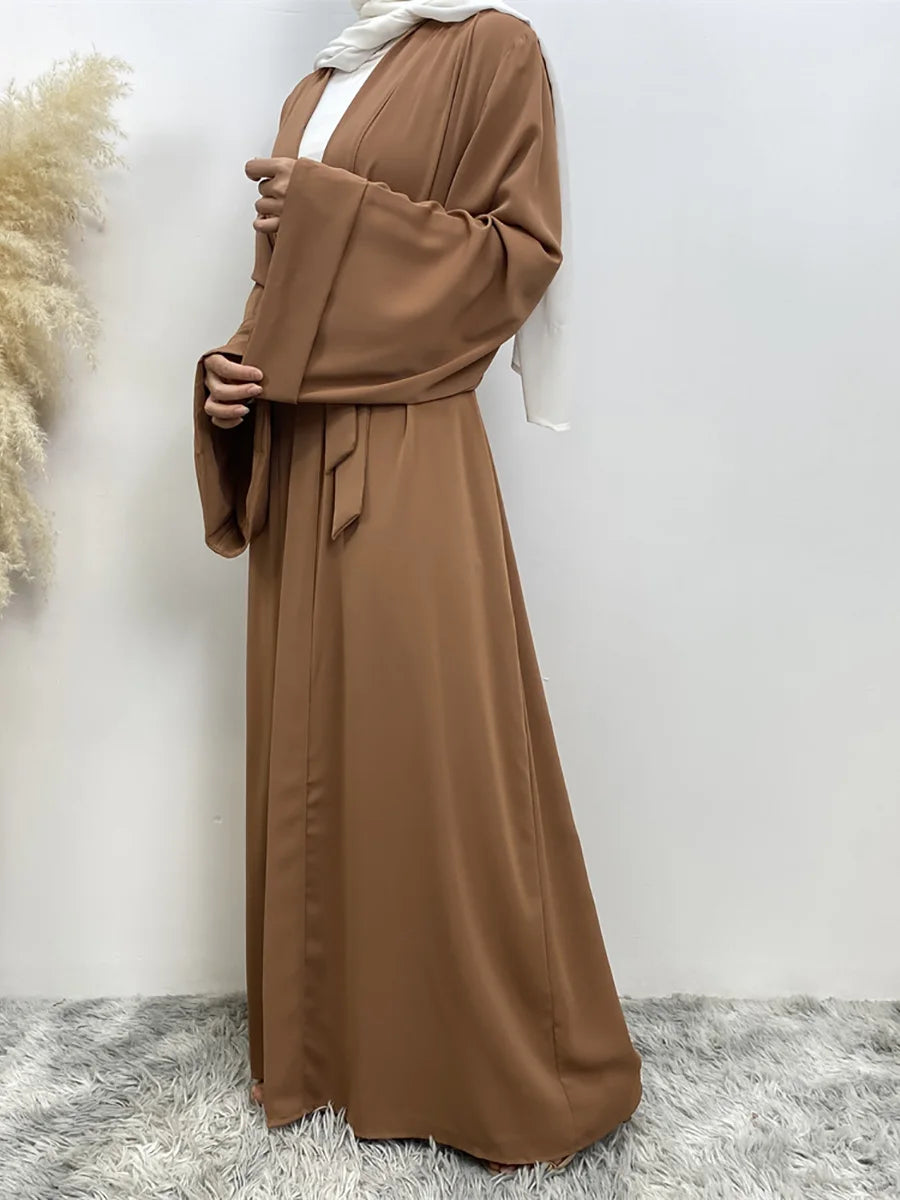 Eine Frau trägt ein fließendes, offenes Abaya Kaftan in mocha-brauner Farbe.