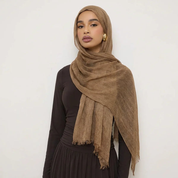 A woman wearing a brown crinkle modal rayon hijab scarf draped over her head and shoulders.