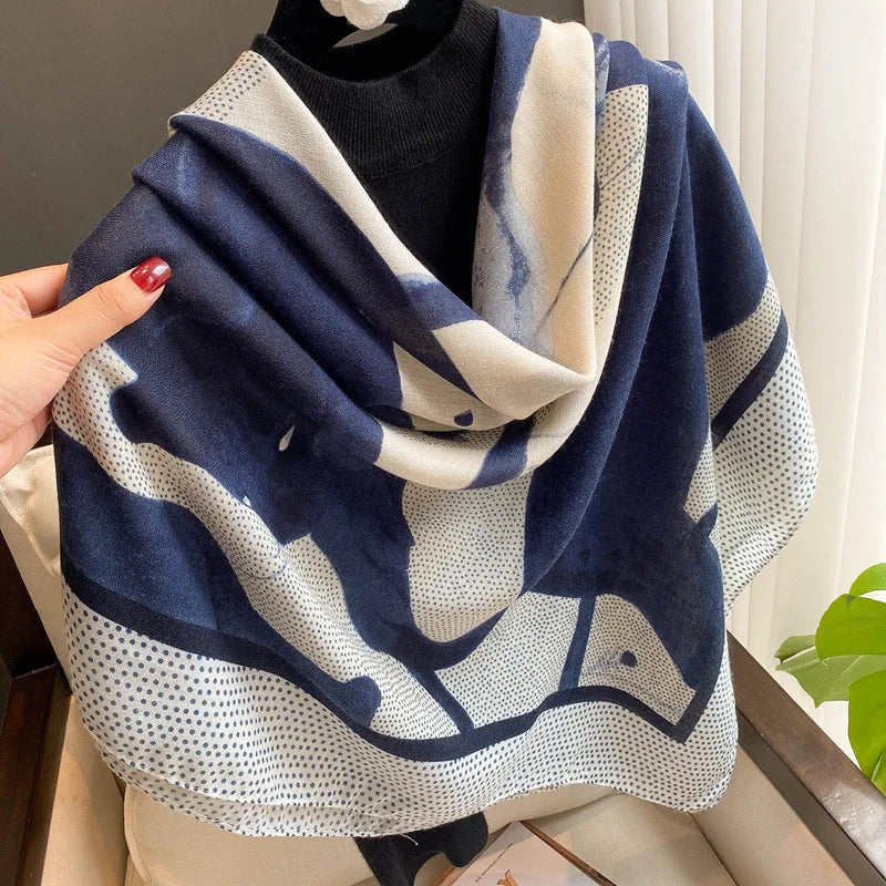 Navy-blaues und weißes gemustertes Viskose-Schal über einem schwarzen Pullover.