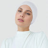 Eine Frau trägt einen weißen Premium-Stretch-Baumwoll-Hijab-Underscarf und ein weißes Rollkragenoberteil.