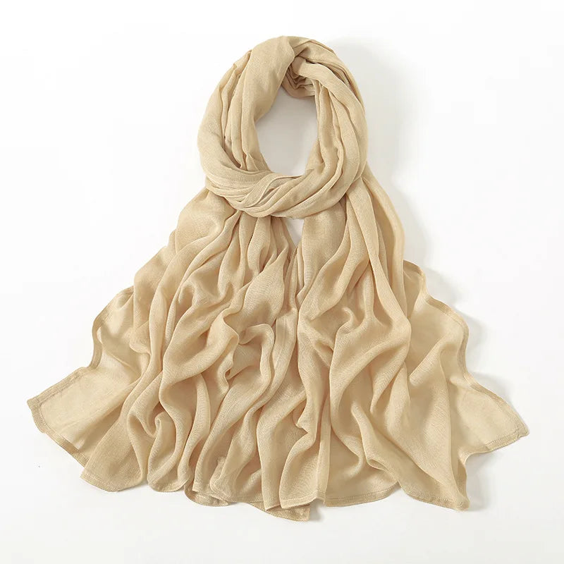 Beige, schlichte Viscose-Hijab elegant um den Hals und die Schultern drapiert.