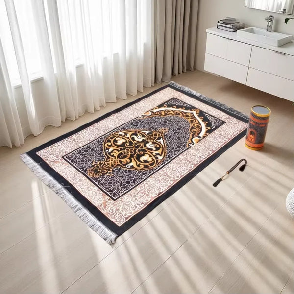 An elegant Islamic prayer rug featuring intricate gold and black patterns on a light wood floor.