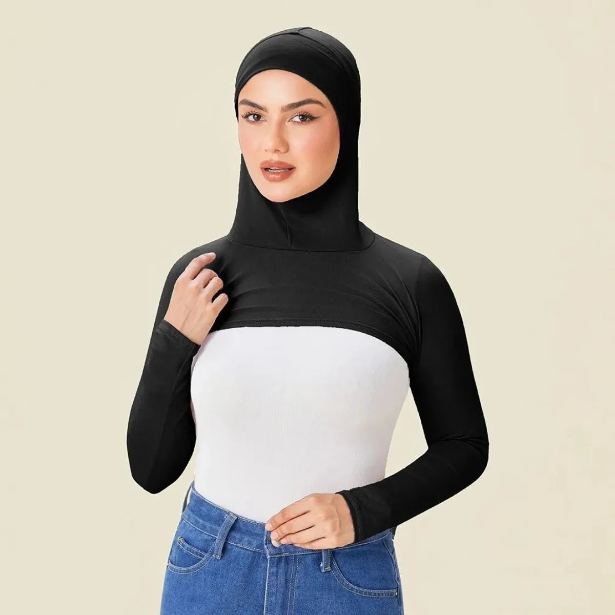 Eine Frau modelliert eine schwarze, elastische, langärmelige Jersey-Schulterjacke für Bedeckung über ein weißes Oberteil und 