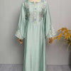 Hellgrüne Abaya mit Blumenstickerei und Pailletten auf einem Mannequin.