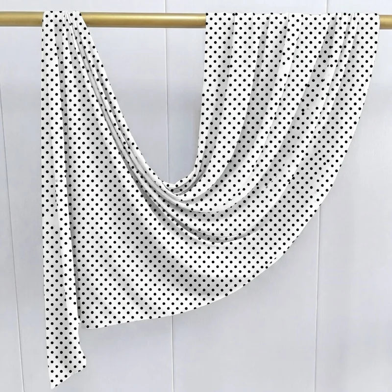 Weißes Hijab-Tuch mit schwarzen Polkadopnt auf einem Holzbügel