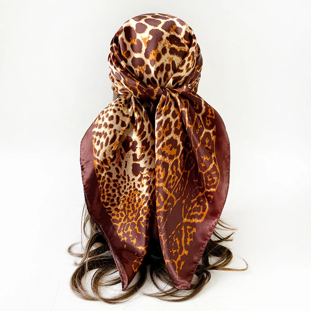 Pañuelo de seda cuadrado con estampado de leopardo atado en lazo, mostrado sobre fondo blanco.