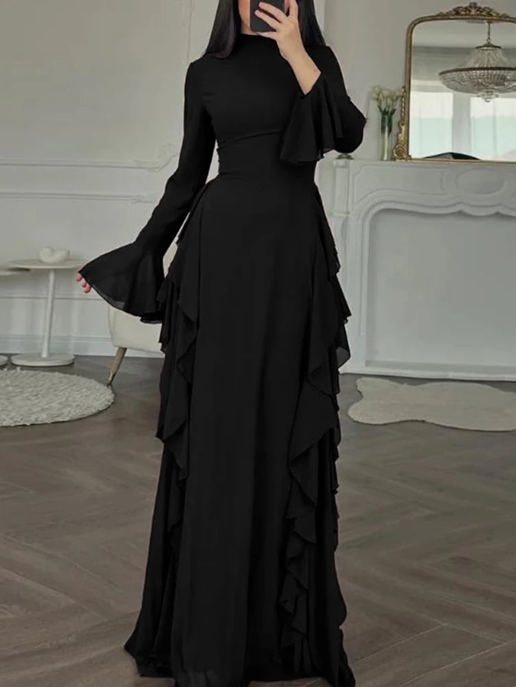 A full-length black maxi dress with a high neckline, long sleeves, and ruffled tiers.