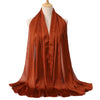 Ein drapierter, verbrannter orangefarbener Satin-Crinkle-Hijab-Schal auf einem Mannequin.