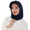 Une femme portant un bonnet hijab couvrant bleu marine et un haut blanc.
