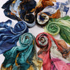 Collection de foulards voiles imprimés élégants dans diverses nuances de bleu, sarcelle, orange et vert.