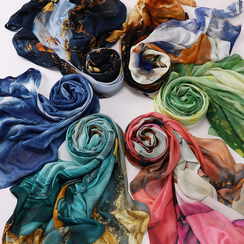 Collection de foulards voiles imprimés élégants dans diverses nuances de bleu, sarcelle, orange et vert.