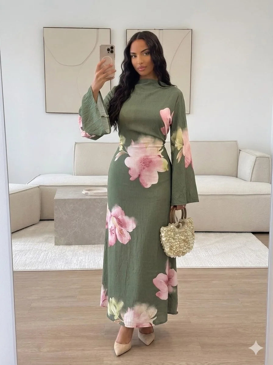 Eine Frau präsentiert ein elegantes Sommer-Blumen-Abaya-Kleid in Olivgrün mit rosa Blumen.