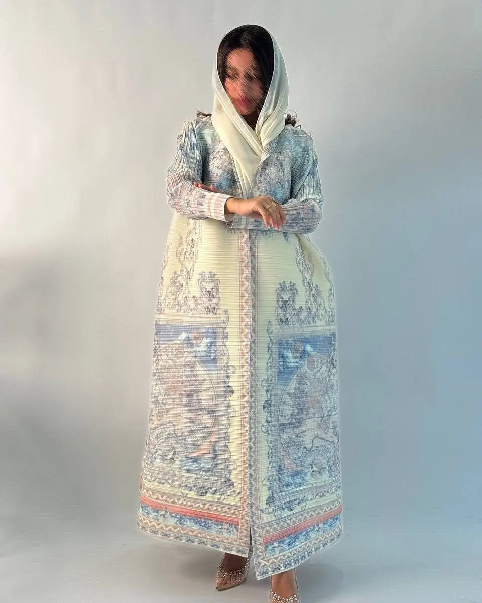 Una mujer vistiendo un cárdigan abaya plisado de color azul claro y blanco con capucha.