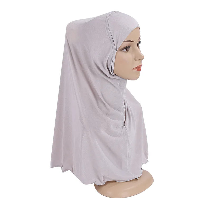 Un chal o pañuelo de Ramadán morado claro infantil, drapeado sobre la cabeza y los hombros de un maniquí.