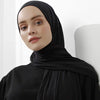 Una mujer vistiendo un pañuelo de hijab de algodón premium negro y elástico, mirando directamente a la cámara.