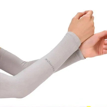 A person is wearing a light gray cooling UV protection arm sleeve on their forearm.