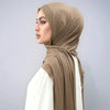 Eine Frau trägt einen beige schimmernden Strass-Seidenschal als Hijab über Kopf und Hals.