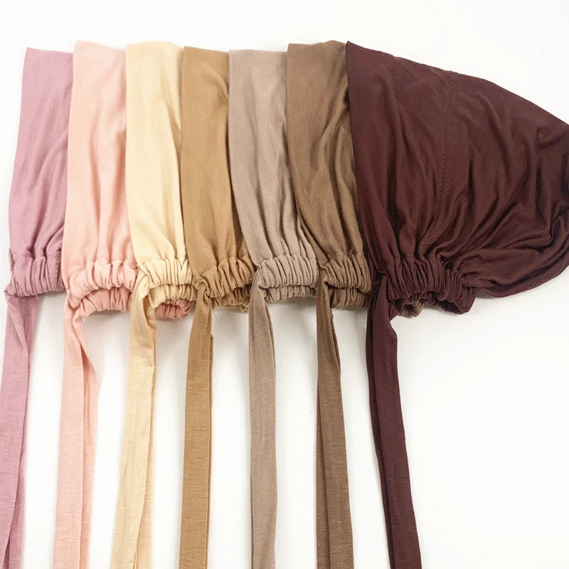 Eine Reihe von mehrfarbigen inneren Hijab-Bindungen in Rosa, Beige, Olivgrün und Braun.