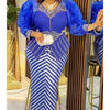 A woman models a royal blue and silver sequin African party dress with puffy sleeves and a diamond necklace.