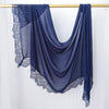 Hijab de encaje azul oscuro drapeado sobre un perchero de madera.